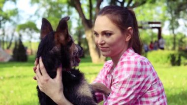 Parkta genç köpeğiyle oynayan güzel bir genç kadın. Yaşam tarzı portresi.