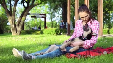 Parkta genç köpeğiyle oynayan güzel bir genç kadın. Yaşam tarzı portresi.