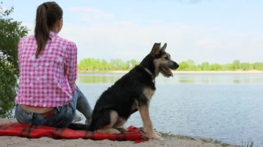 Dişi, göl kenarında evcil hayvanla yazın tadını çıkarıyor. Güzel, mutlu köpek açık havada, inanılmaz manzara parkı doğası köpek yavrusu sahibi hoş bir an, sağlıklı yaşam tarzı konsepti..