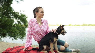 Dişi, göl kenarında evcil hayvanla yazın tadını çıkarıyor. Güzel, mutlu köpek açık havada, inanılmaz manzara parkı doğası köpek yavrusu sahibi hoş bir an, sağlıklı yaşam tarzı konsepti..