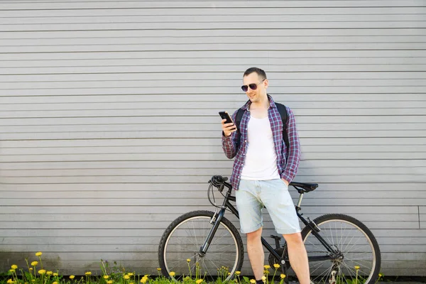 Mann Mit Smartphone Und Fahrrad Steht Vor Wand — Stockfoto