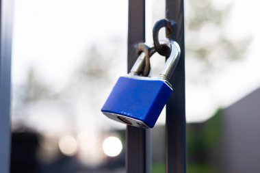 Metal çitin üzerindeki mavi eski kilit. Yakın plan..