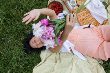 Yaz parkında piknikte çiçekli güzel bir Asyalı kız
