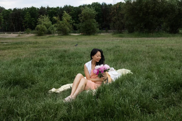 美丽的年轻亚洲女孩 带着鲜花在夏季公园野餐 — 图库照片