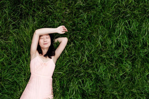 一个年轻的亚洲女人躺在草地上的画像 复制空间 — 图库照片