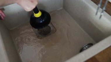 drenaj. Delik tıkanmasını temizlemek için lavabo pompası kullanıyor. Lastik boru pompasıyla tıkanmış borular temizleniyor. Tıkanmış kanalizasyonu açmak için tesisat aletleri. Kanalizasyon borusu tıkanıklığı sorunu çözümü.