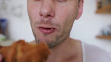 Kızarmış tavuk kanadı yiyen heyecanlı aç adam. Beyaz adam abur cuburdan hoşlanıyor. Yüksek kalorili yiyecekler, sağlık riskleri, kolesterol. Erkek ağzını kapat ve içeride abur cubur ye.. 