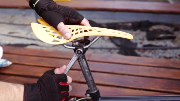 장갑을 산악자전거 프레임에 렌치를 사용하여 볼트를 자전거 시트를 고칩니다 도로에 — 비디오