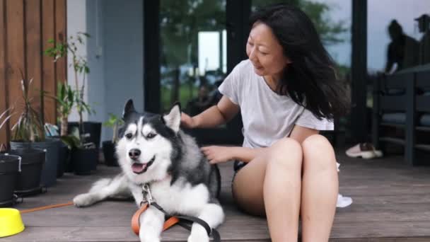 Jonge Eigenaar Vrouw Haar Hond Husky Zitten Buurt Van Huis — Stockvideo