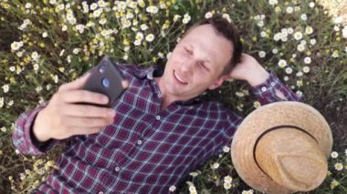 Papatya çayır çiçekli genç adam selfie çek..