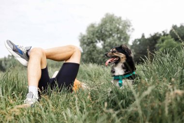 Mutlu arkadaşlar adam ve köpek Labrador yaz parkında çimlerde oturuyor.. 