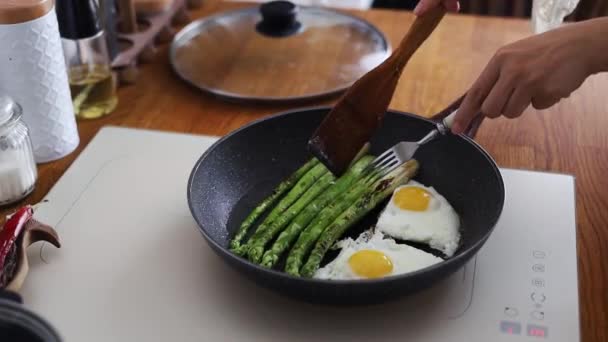 鲜嫩的芦笋及用牛油在锅中煮熟的鸡蛋 — 图库视频影像