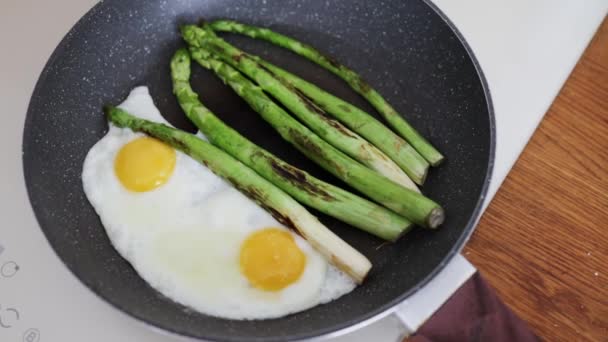 鲜嫩的芦笋及用牛油在锅中煮熟的鸡蛋 — 图库视频影像