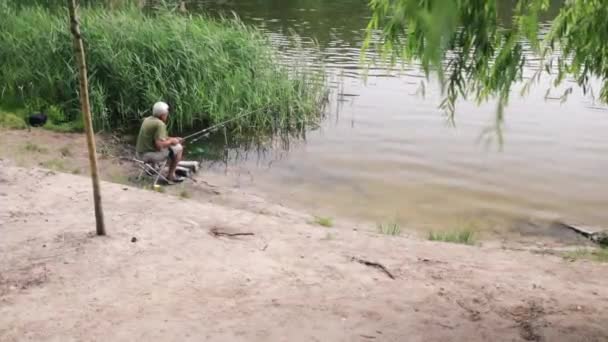 Πίσω Όψη Παλαιωμένου Ψαρά Που Κάθεται Κοντά Στη Λίμνη Και — Αρχείο Βίντεο