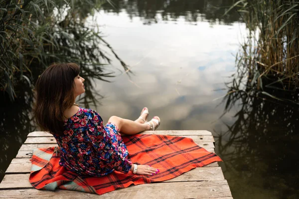 Kobieta Relaksuje Się Nad Jeziorem Siedząc Krawędzi Drewnianego Mola Koncepcja — Zdjęcie stockowe