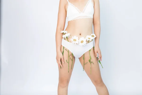 美丽的年轻亚洲女人 身材苗条 身穿内裤 开着雏菊花 身体护理和洁净的皮肤 描述的概念 一个漂亮女人的蜡 — 图库照片