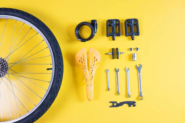 一套不同的自行车工具和零件在黄色的背景上 案文的篇幅 — 图库照片