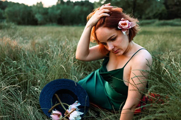美丽的年轻女子手持水百合花的夏季生活方式肖像 坐在草地上 享受阳光吧 幸福与爱情的概念 呆滞的眼睛 — 图库照片