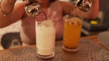 Woman barista making iced black coffee with orange juice in takeaway glass. coffee shop waiter serving coffee to customer on counter at cafe. Small business cafe and restaurant owner concept.