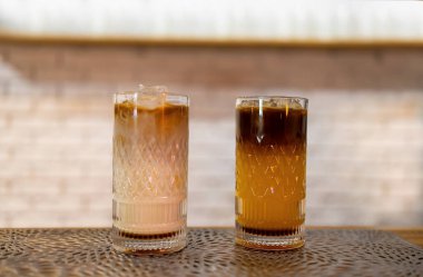 Two macaroons and iced black coffee with orange juice in cafe. Small business cafe and restaurant owner concept.