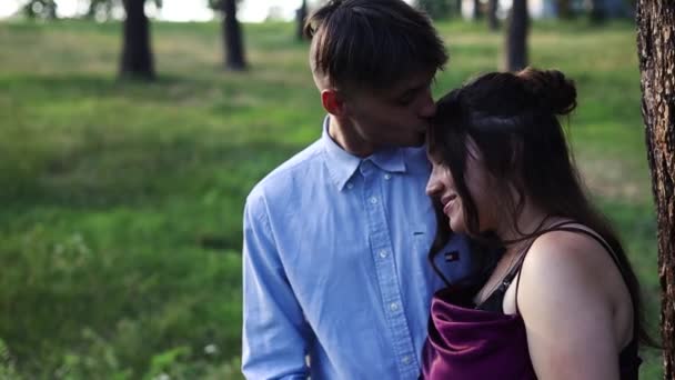 在夏日 一对年轻的怀孕夫妇靠着一棵大树 一对年轻的怀孕夫妇在外面共度时光 — 图库视频影像