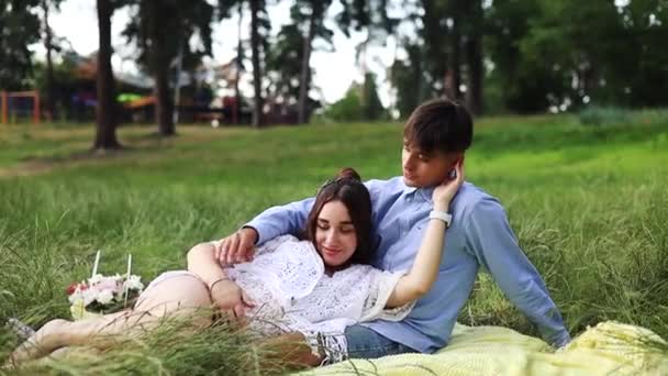 Happy Pregnant Couple Sitting Grass Park Happy Young Pregnant Couple — Vídeo de Stock