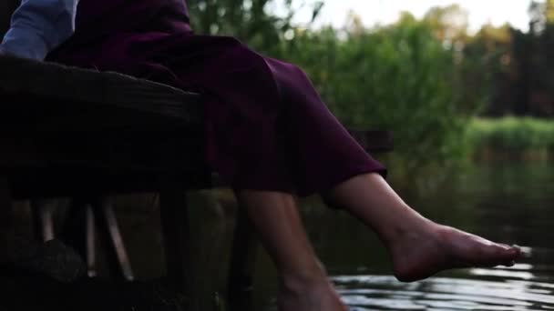 Una Mujer Descansa Junto Lago Sentada Borde Muelle Madera Balanceando — Vídeo de stock