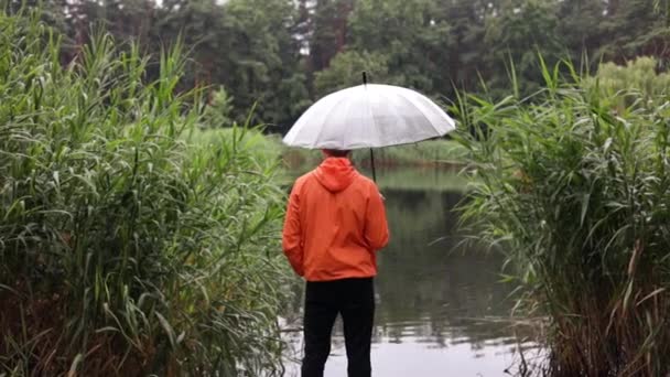 Bakåt Ung Man Orange Regnrock Med Ett Paraply Stående Träpir — Stockvideo