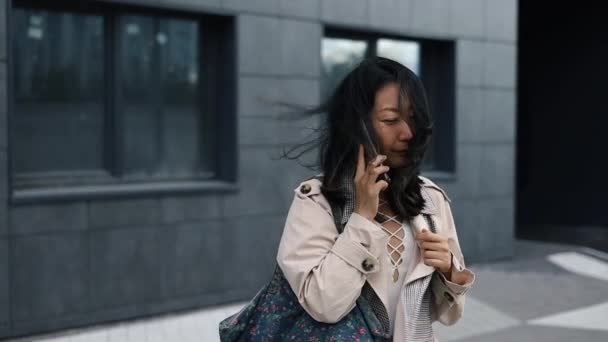 一个时髦的亚洲女人用智能手机说话的肖像 城市女商人在手机上聊天时的别致肖像 聪明的人手里拿着电话 — 图库视频影像