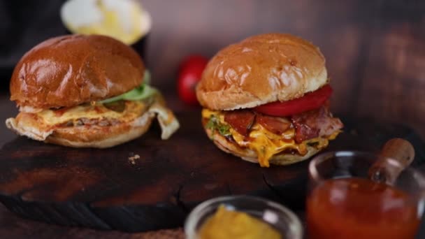 带有牛肉 西红柿 熏肉和生菜的美味烤土制汉堡包 背景为乡村木质 快餐和垃圾食品概念 — 图库视频影像