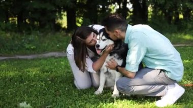Sibiryalı köpekli mutlu çift yaz parkında. Aşk konsepti.