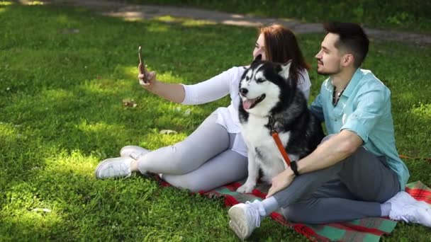 Young Couple Cute Husky Dog Taking Selfie Green Grass Summer — Stock Video