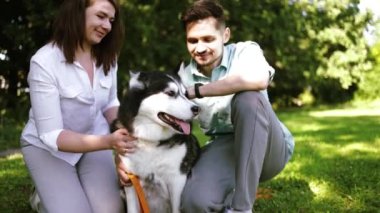 Sibiryalı köpekli mutlu çift yaz parkında.