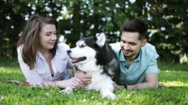 Sibiryalı köpekli mutlu çift yaz parkında.
