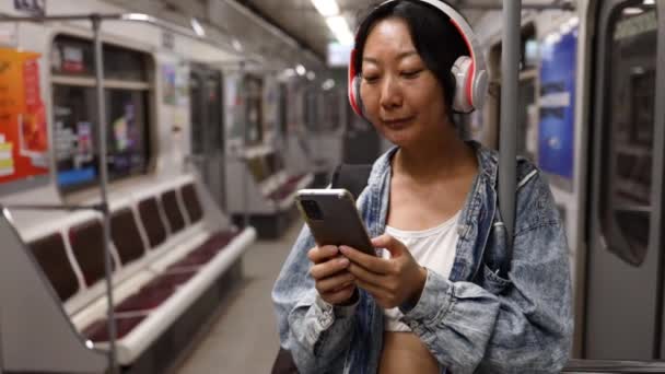 Fiatal Ázsiai Lány Utazik Metrón Nézi Telefont Zenét Hallgat Fejhallgatón — Stock videók