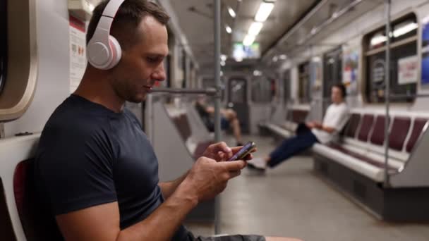 Νεαρός Που Χρησιμοποιεί Κινητό Του Ενώ Κάθεται Στο Μετρό Και — Αρχείο Βίντεο