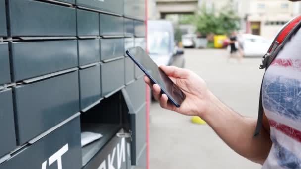 Adam Açık Havada Akıllı Telefon Kullanarak Posta Kutusundan Paket Alıyor — Stok video