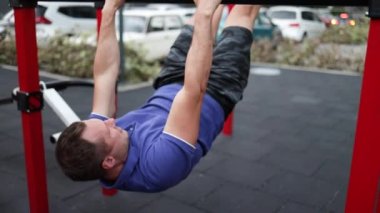 Şişirilmiş gövdesi olan yakışıklı sporcu kolları üzerinde egzersiz yapıyor. Beyaz tenli atletizm sporcusu kaslarını şişiriyor.. 