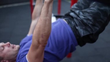 Şişirilmiş gövdesi olan yakışıklı sporcu kolları üzerinde egzersiz yapıyor. Beyaz tenli atletizm sporcusu kaslarını şişiriyor.. 