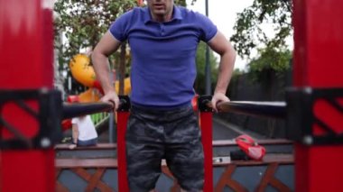 Şişirilmiş gövdesi olan yakışıklı sporcu kolları üzerinde egzersiz yapıyor. Beyaz tenli atletizm sporcusu kaslarını şişiriyor.. 