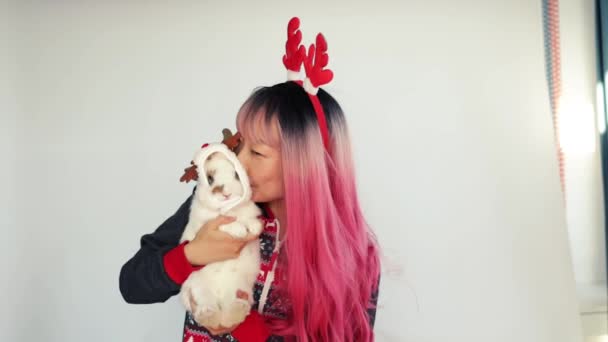 Funny Asian Girl Christmas Reindeer Antlers Holding Bunny Smiling White — Stock Video