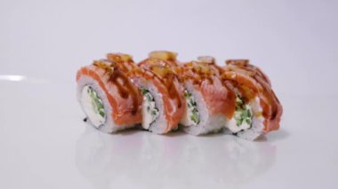Somonlu suşi rulosu (Philadelphia), füme yılan balığı, beyaz arka planda izole edilmiş krem peynir. Suşi menüsü. Japon yemeği..