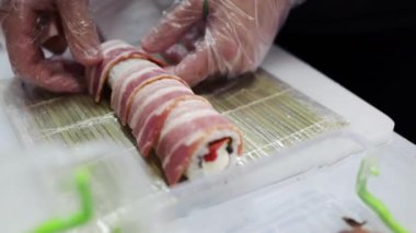 Pirinçli suşi, pastırma ve nori pişiriyorum. Japon uzman suşi şefi suşi yapıyor..
