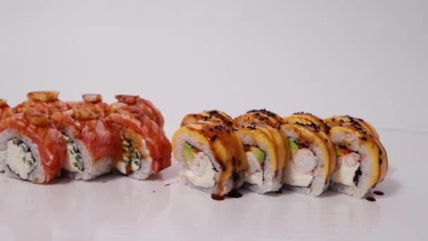異なる種類の寿司 マグロとサーモンとロール 白い背景にライスキャビアと魚 — ストック動画