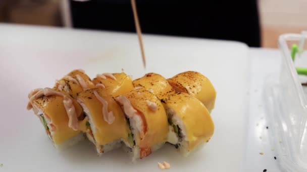 寿司を作るシェフは ゴマの種子でソースを注ぐ ソースを落とした新鮮な寿司 日本の寿司ロール アジア料理 寿司レストラン閉店 — ストック動画