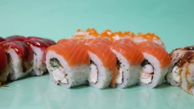Somonlu suşi rulosu (Philadelphia), füme yılan balığı, beyaz arka planda izole edilmiş krem peynir. Suşi menüsü. Japon yemeği..