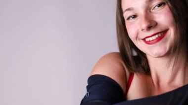 Vücut pozitifliği ve kendini sevme kavramı. Neşeli vücudun belden yukarı vuruşu pozitif genç kadın aşkın kendi vücudunun beyaz duvarın üzerinde kırmızı iç çamaşırı durduğunu hissediyor.