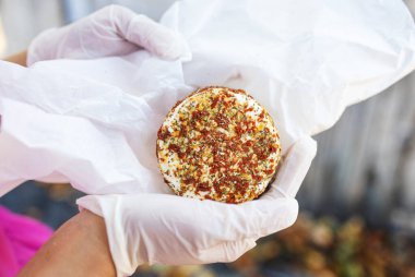 Çiftçi kadın kırsal alanda peynirin kalitesini kontrol ediyor.