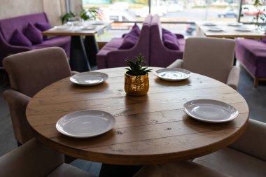 Çok güzel organize edilmiş bir etkinlik. Konuklar için yuvarlak masa ziyafeti, boş tabaklar, bardaklar, çatallar ve peçetelerle süslenmiş yuvarlak masa. Zarif bir yemek masası..