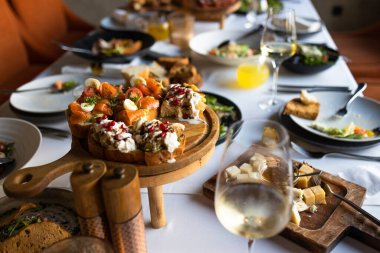 İştah açıcı taze aperatifler, beyaz tabaklar üzerinde servis edilen ziyafet masasında, restoranda masa örtüsü ile..